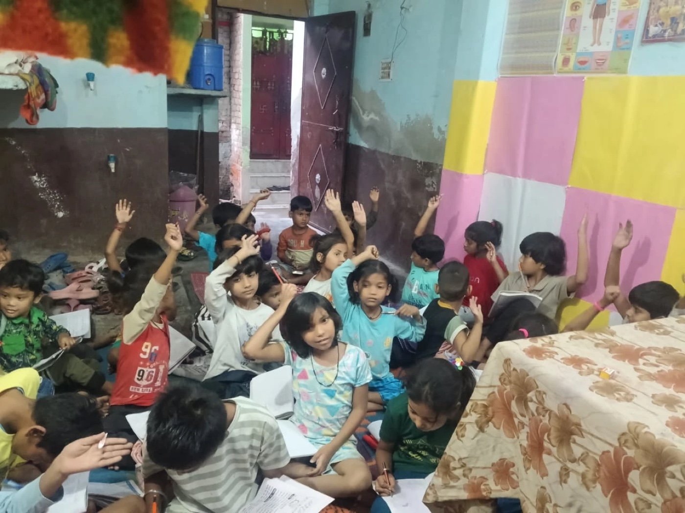 Children raising hands at an Aadi Foundation learning centre